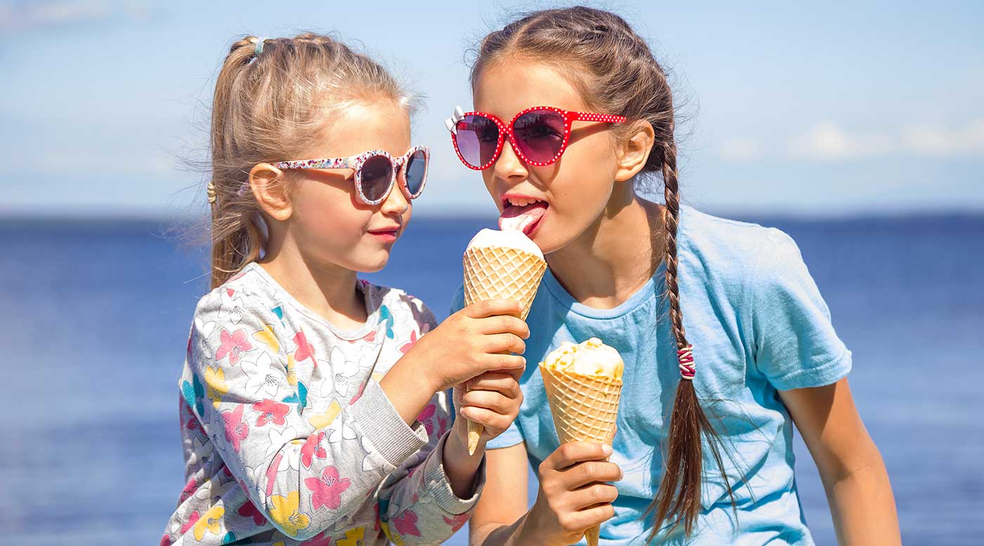 Zwei Kinder am Strand essen Eis